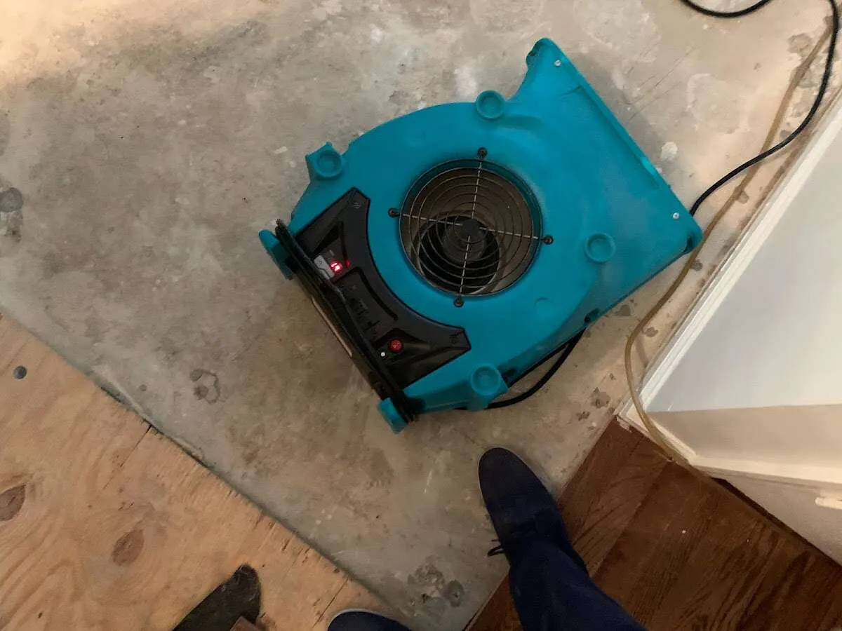 Air mover drying subfloor during Leak Detection & Repair in Gates
